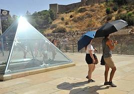Passers-by carry umbrellas to protect themselves from the sun last Sunday in Malaga city.