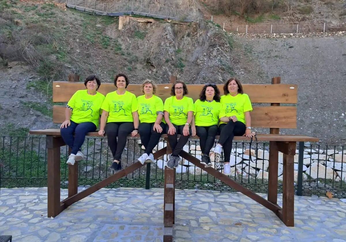 A group of women sitting on the giant bench in Árchez