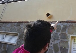 A resident points to marks on the wall of his house left by the burglars.
