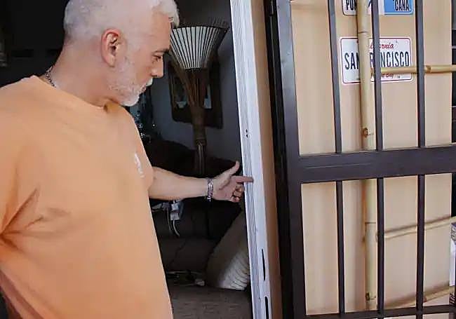 David Gómez points to damage to his terrace door following the burglary