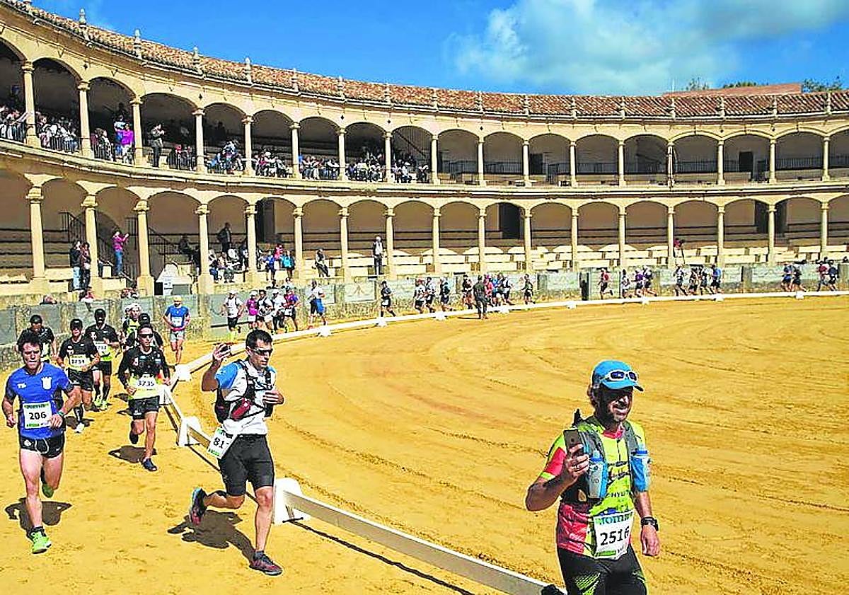 Imagen principal - From top: Runners in the Ronda 101km in the famous bullring, Ultra Sierra Nevada competitors at the ski resort and a runner in the Seville marathon passes the iconic cathedral.
