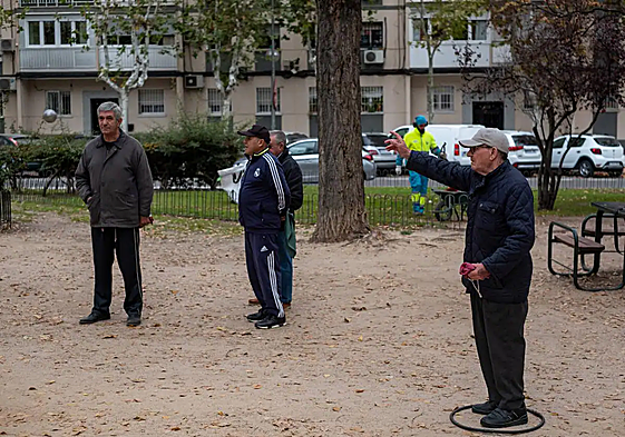 A group of elderly people playing petanque.