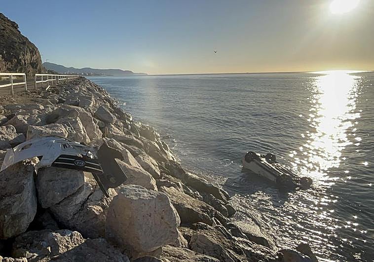 The overturned vehicle lies in the sea after crashing over the Calaceite breakwater from the old N-340 in Torrox-Costa.