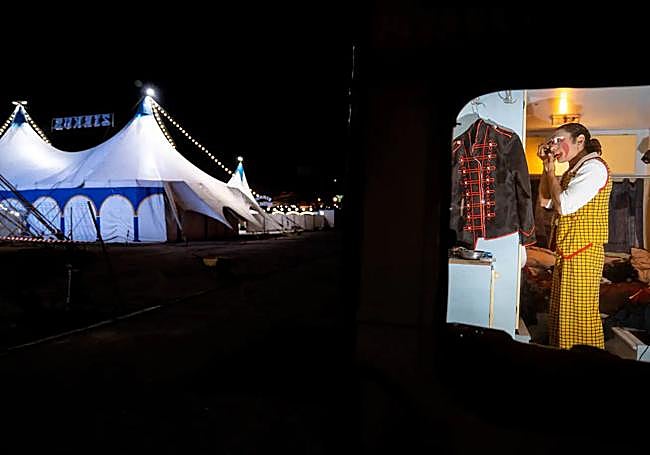 Andrea puts his make-up on in his van.