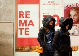 Two women shelter from the cold and rain yesterday in the centre of Malaga.