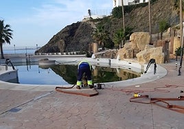 Municipal workers extract donated water from a Benalmádena hotel swimming pool.