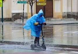 An electric scooter rider battles the elements in Malaga city centre.