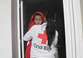 A Cruz Roja volunteer carries a child.