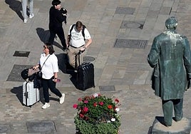 Tourists, suitcases in hand, in Malaga city centre.