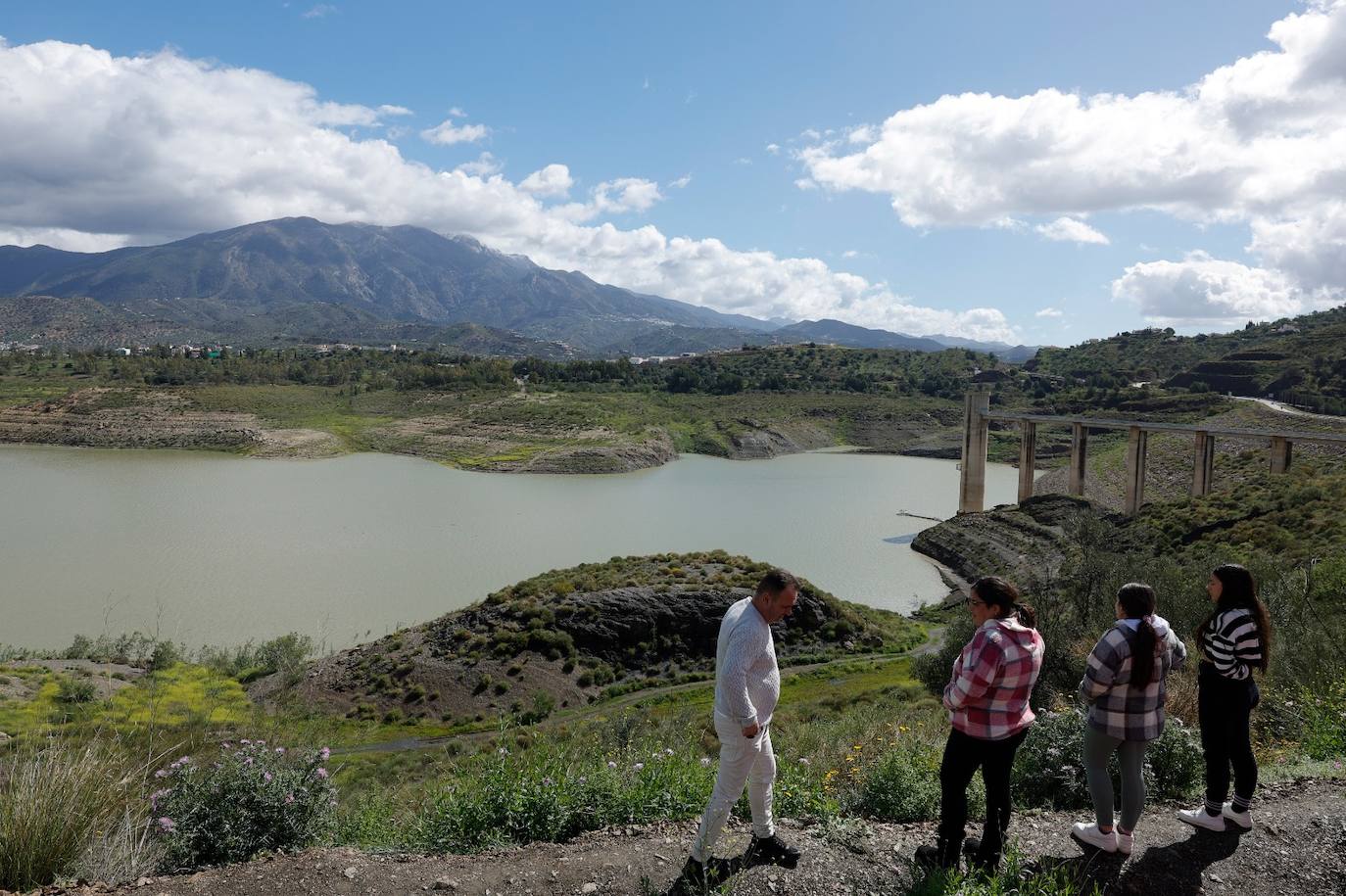 A group of people take in a view of the reservoir, which has floating pumps installed due to the drought crisis.