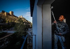 A worker finishes the painting work in one of the rooms on the upper floor of the Casa de los Guardeses.