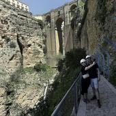 A couple take a selfie with the Tajo de Ronda in the background, on the Caminito del Desfiladero