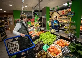 A woman shops for fruit and veg.