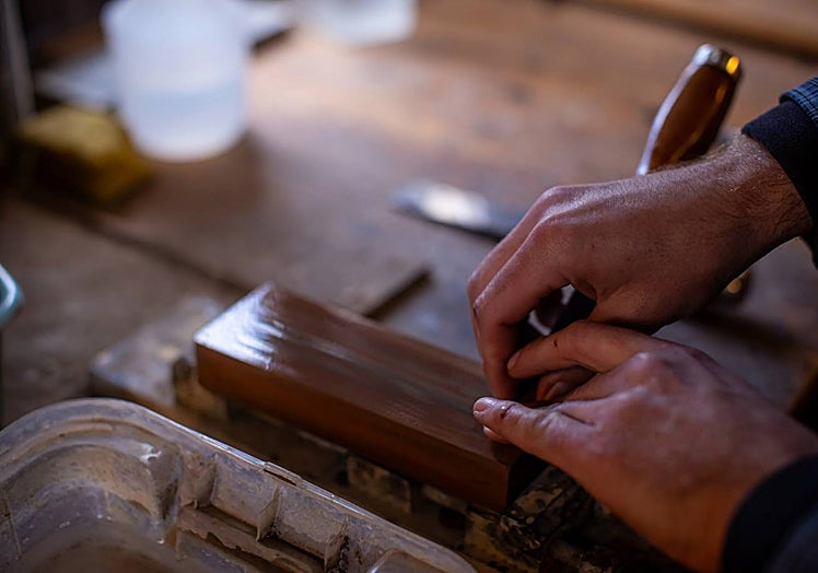 The guitar maker sharpening chisels.