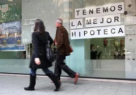 Two passers-by in front of a bank's poster promoting their mortgages.