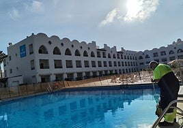 An employee of Benalmádena Town Hall collects water from a hotel swimming pool, donated for irrigation