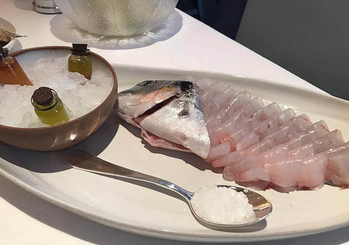 Imagen principal - Above, carpaccio of sea bream, which is one of the most striking dishes on Gaia's menu. The cut of the fish is not that of the traditional carpaccio, it is a thicker cut and is served with three different types of dressings that the diner chooses. Below, Astakomakaronada, this almost unpronounceable dish is another of the most demanded and recommended dishes on the menu. Fresh pasta, in this case linguini, dressed with a tasty cherry tomato and seafood sauce and half a lobster. Below, yogurt ice cream, a classic dessert based on a very well prepared Greek yogurt ice cream that is lightly bathed in syrup to enhance its sweet taste. The walnuts that crown it only add to the dessert.