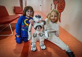 Guiomar and her brother Darío with the therapeutic robot Juande.