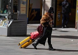 A tourist pulls her suitcase through the streets of Madrid.