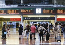 Passengers in front of the train information panels at María Zambrano railway station in Malaga city.