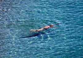 A man enjoys a swim at a beach in the province of Malaga.