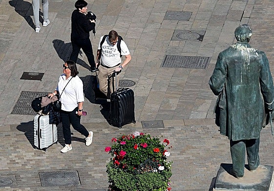 Tourists, with their suitcases, in the centre of Malaga.