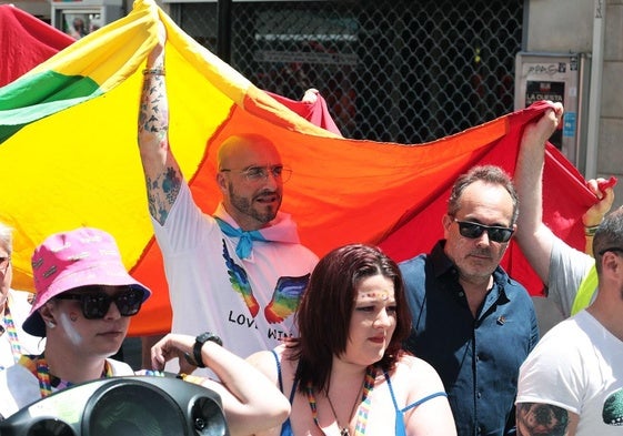 Minister for Equality Christian Santos holds the LGBT flag.