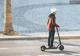 A teenager rides an electric scooter.