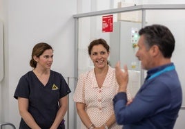 Minister Arias-Vasquez (c) with health care workers at the opening ceremony.