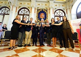 Group photo celebrating the centenary with a toast from a bottle of one of Malaga's DOP wines.