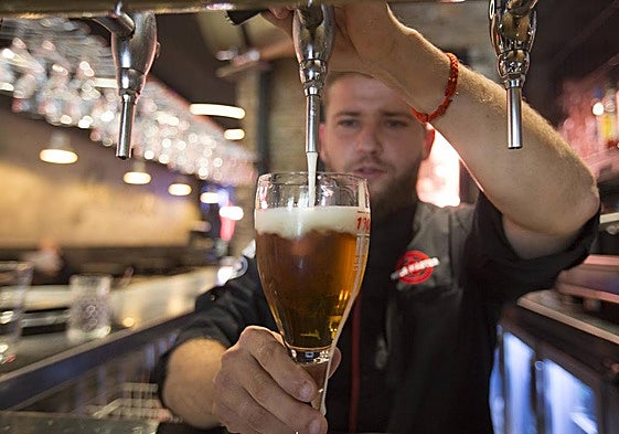 A waiter pouring beer in an archive image.