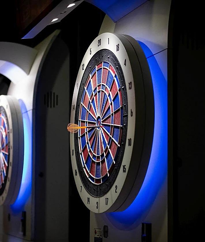 Imagen secundaria 2 - Top, players at the Pizarra darts competition; bottom left, professional player Riky Pérez; bottom right, one of the dart boards in use. 