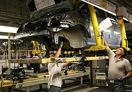 Workers on a vehicle assembly line.