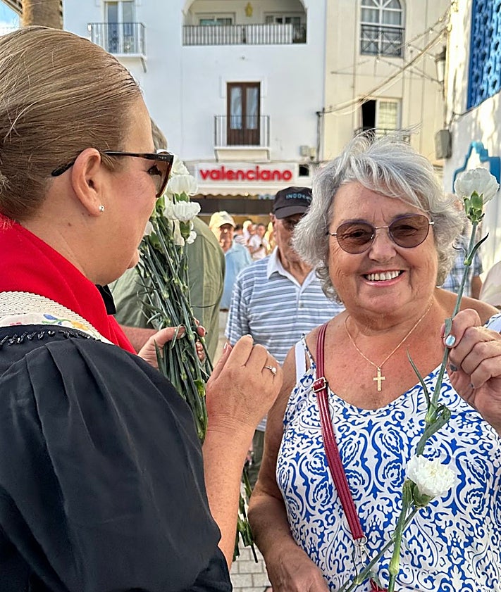 Imagen secundaria 2 - Miguel de Miguel receiving his award; dancers on the Balcón de Europa; a tourist receives a white carnation.