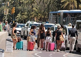 File image of tourists waiting with their luggage at a taxi rank in Malaga city centre.
