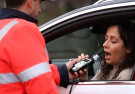 A driver takes a breathalyser test at a drink-drive checkpoint.