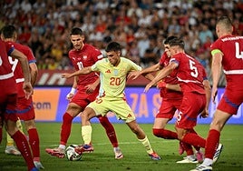 Spain midfielder Pedri surrounded by Serbia players.