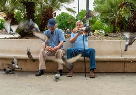 Pensioners sat on a park bench in Spain.