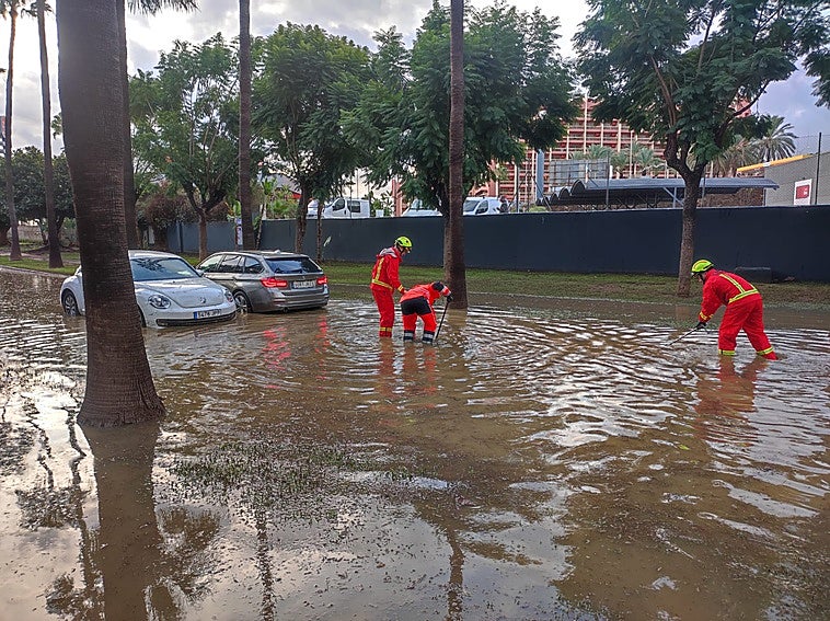 Firefighters work in a flooded area of Benalmádena.