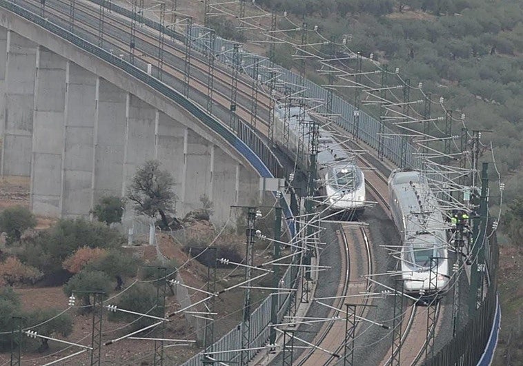 A train passes by the derailed train.
