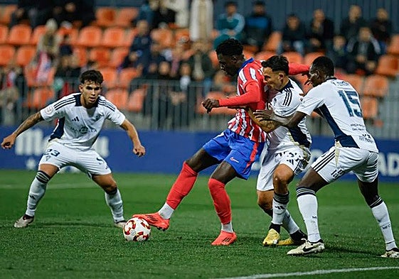 Three Marbella players attempt to win back the ball.