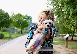 Paqui Téllez hugs her recently adopted dog Yari in a park near her home.