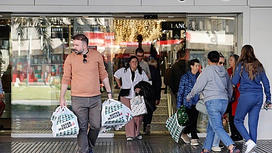 When will the shops be open in Malaga and along the coast over this long holiday weekend in Spain?