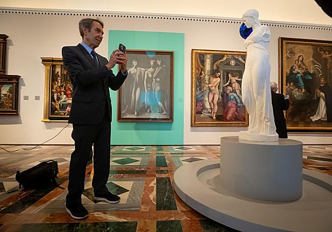 Koons takes a photo of one of his sculptures; behind is the Three Graces by Picasso.
