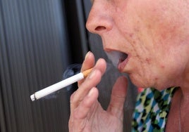 A woman smokes a cigarette.