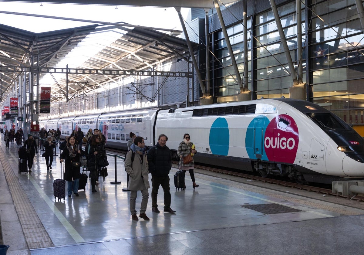 Rail passengers walk past the first Ouigo train that has arrived in Malaga.