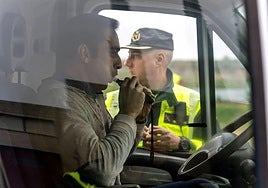 A driver takes a breathalyser test during a Guardia Civil roadside check.