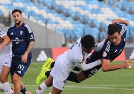 A Marbella player strikes an acrobatic pose while challenging for the ball.
