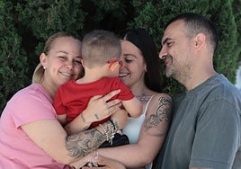 In the picture, the parents of little Romeo, who is being held by his sister.