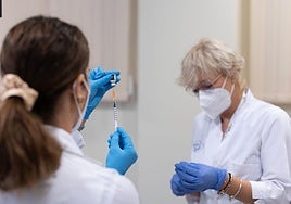 Two nurses prepare the vaccines.